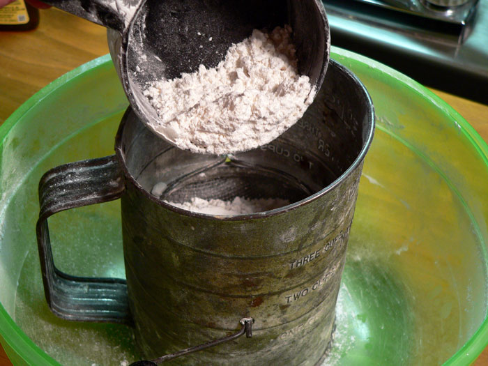 Begin making the cobbler by placing one level cup of self-rising flour in a sifter.