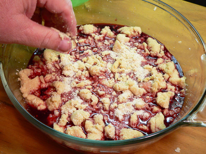 With your hands, drop the portions of the topping all around the top of the cherry mixture.