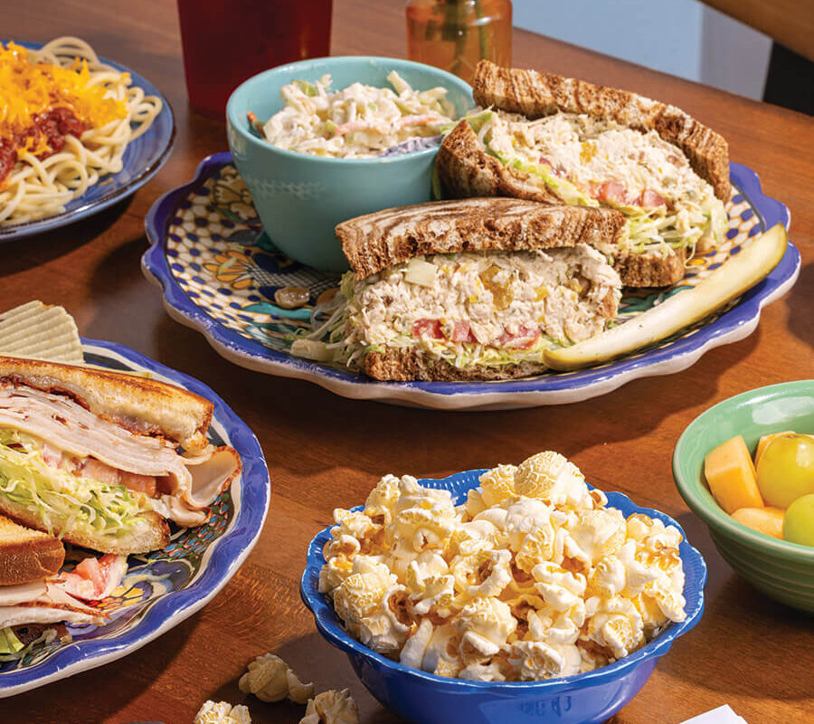 Table with assorted sandwiches and side of popcorn at Three Chopt Sandwich Shoppe in Hendersonville