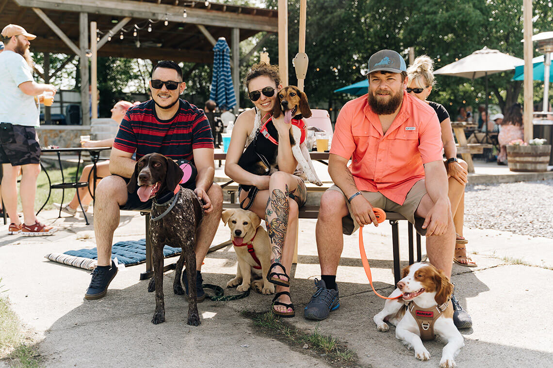 People with dogs on the patio at 2Witches Winery & Brewing Company