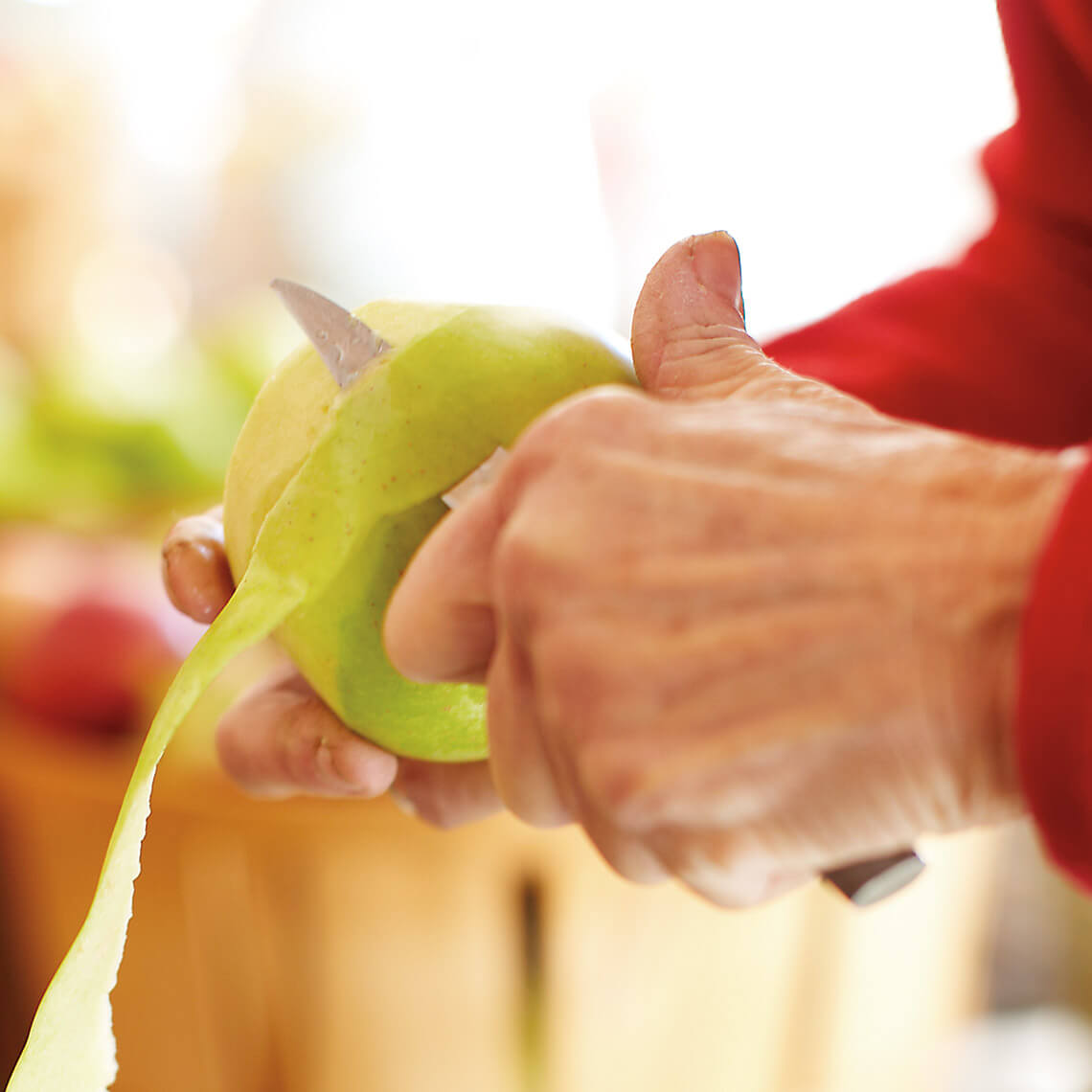 Hands peeling apples