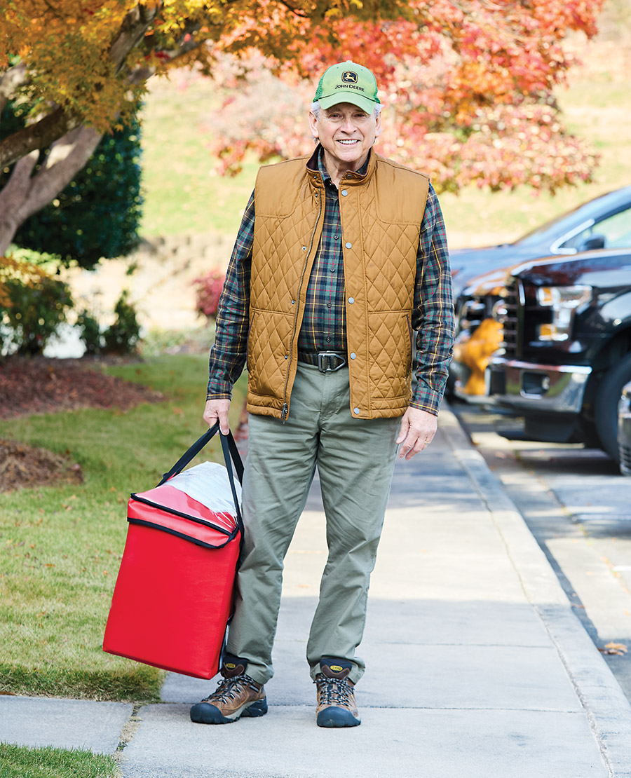 Franklin Plummer carries a cooler for his meals on wheels delivery route