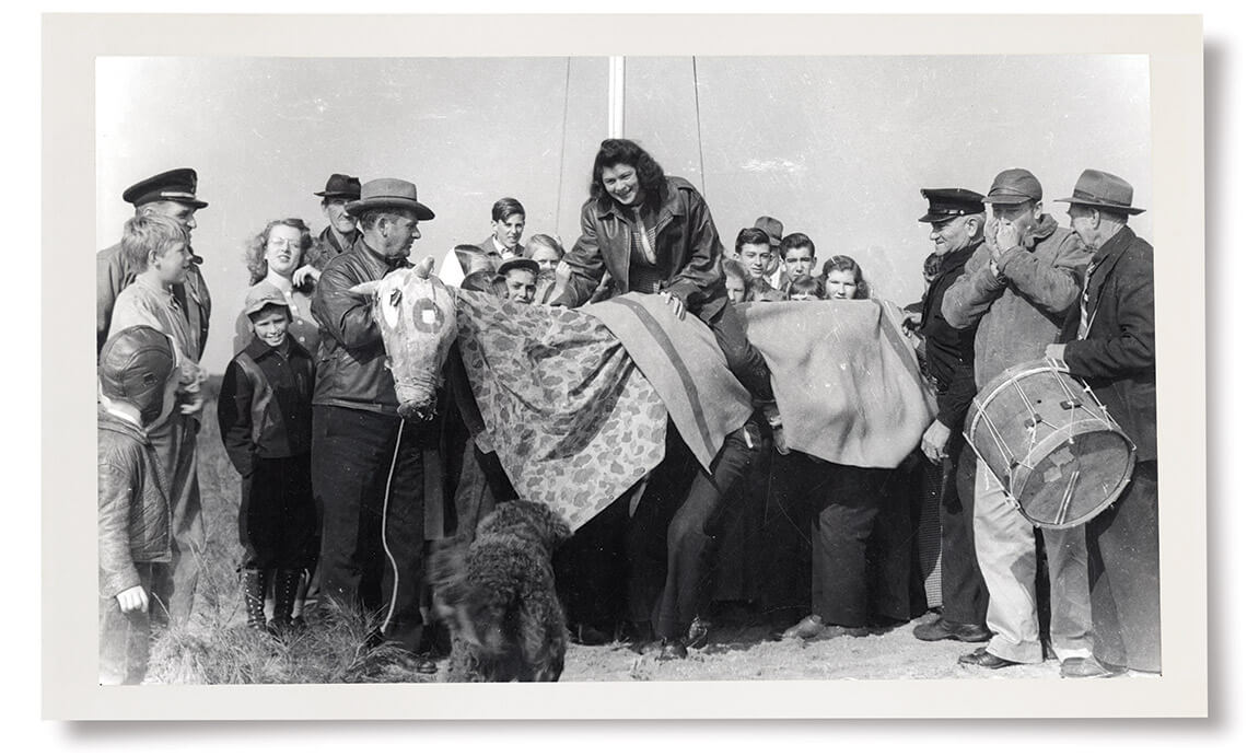 Black and white photo of villagers with Old Buck character at Old Christmas