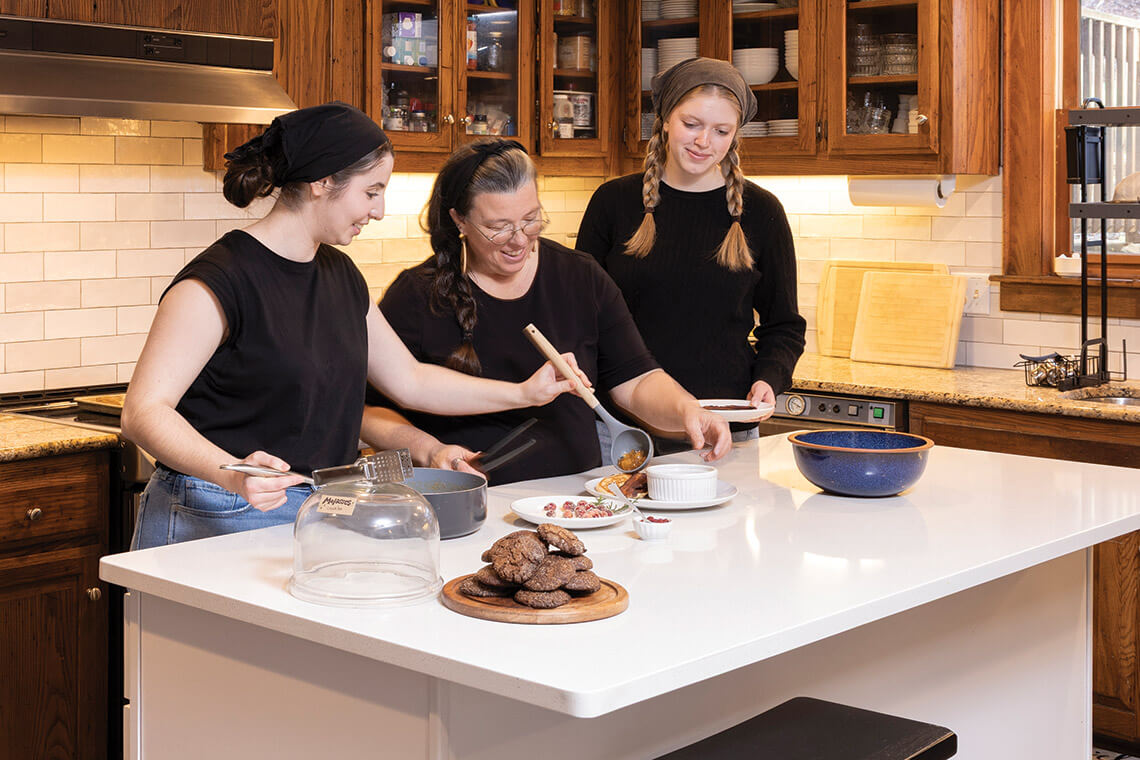 Cosette Rieflin, Emma Shae Morrow, and Alison Dees prepare breakfast for guests at Lovill House