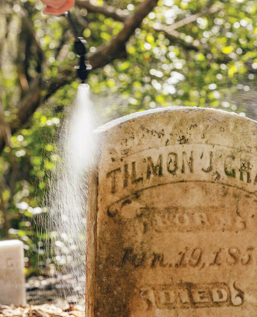 Dawn Taylor cleans a gravestone