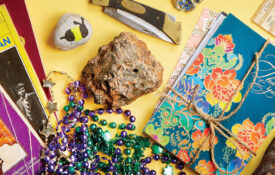 Collected thank you cards, old books, and Mardi Gras beads the author has collected